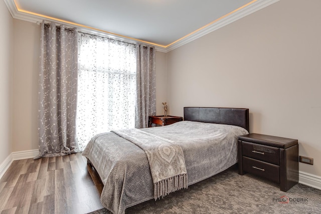 bedroom featuring baseboards, ornamental molding, and wood finished floors