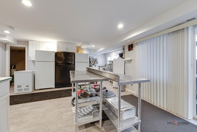 kitchen with freestanding refrigerator, white cabinetry, visible vents, and recessed lighting