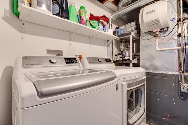 laundry room with heating unit, laundry area, and washing machine and clothes dryer