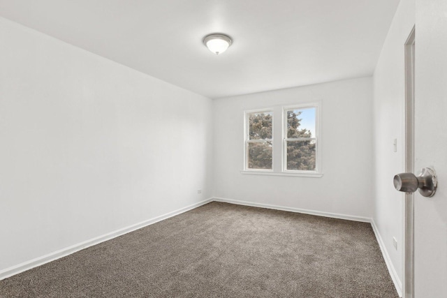 unfurnished room featuring baseboards and dark colored carpet