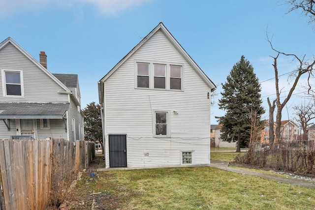 back of property featuring a yard and fence