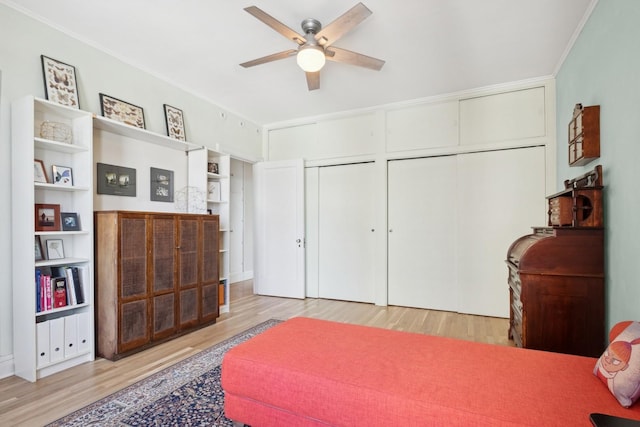 bedroom with wood finished floors, a ceiling fan, and crown molding