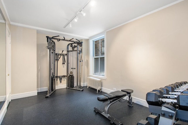 exercise area with radiator, baseboards, track lighting, and ornamental molding