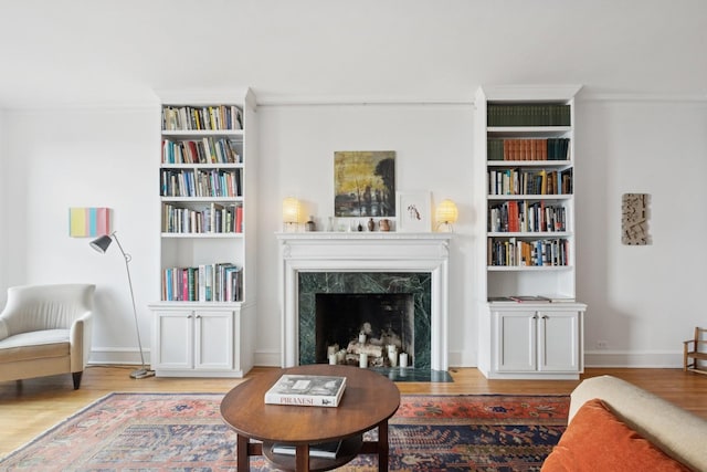 sitting room with wood finished floors, baseboards, and a premium fireplace