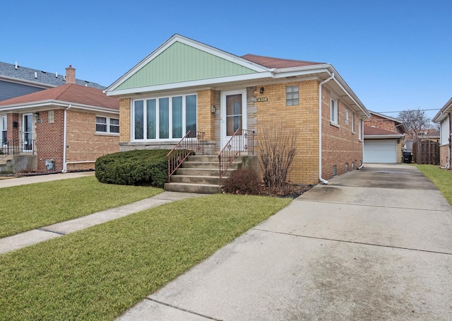 view of front of home featuring an outbuilding, brick siding, a detached garage, a front yard, and crawl space