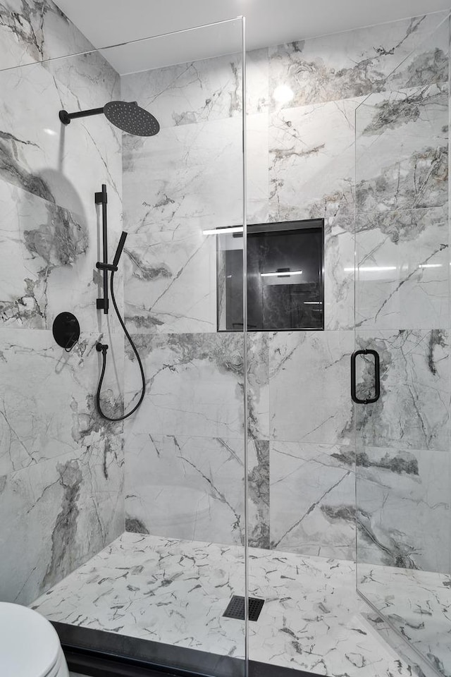 full bathroom featuring a marble finish shower and toilet