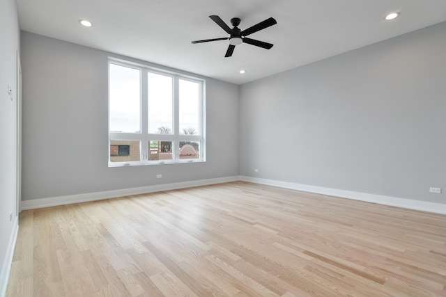 empty room featuring light wood finished floors, recessed lighting, and baseboards