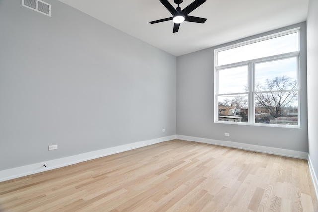 empty room featuring light wood-style floors, visible vents, ceiling fan, and baseboards