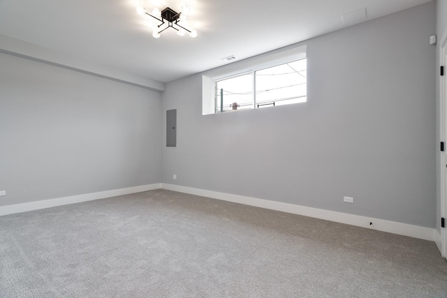 empty room featuring visible vents, carpet, electric panel, and baseboards