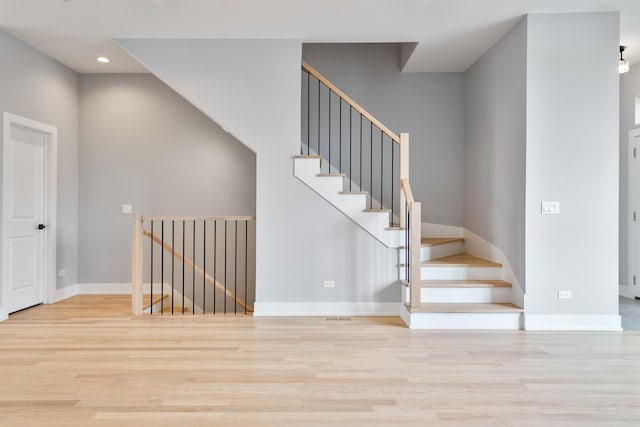 staircase with recessed lighting, baseboards, and wood finished floors