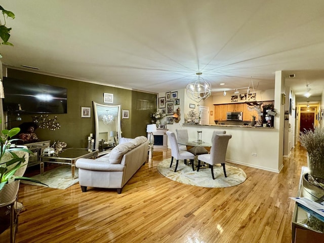 living area featuring light wood-style flooring and a notable chandelier