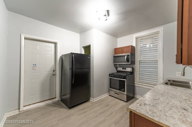 1932 W 22nd Pl, Chicago, IL 60608 - kitchen featuring baseboards, stainless steel appliances, light countertops, light wood-type flooring, and a sink