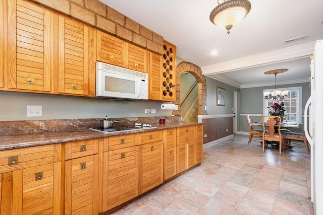 kitchen with arched walkways, crown molding, visible vents, dark stone counters, and white appliances