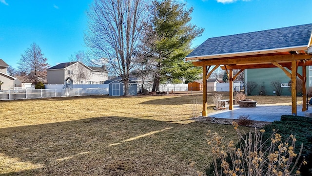 view of yard featuring an outdoor fire pit, a fenced backyard, a patio, and a shed