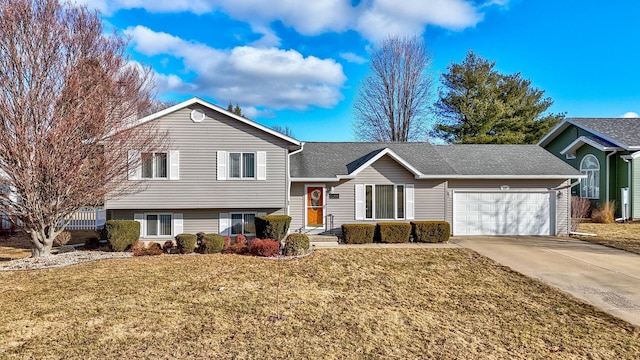 split level home featuring an attached garage, a front lawn, and concrete driveway