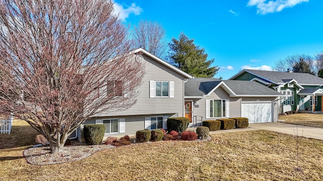 split level home with a garage, driveway, and a front yard