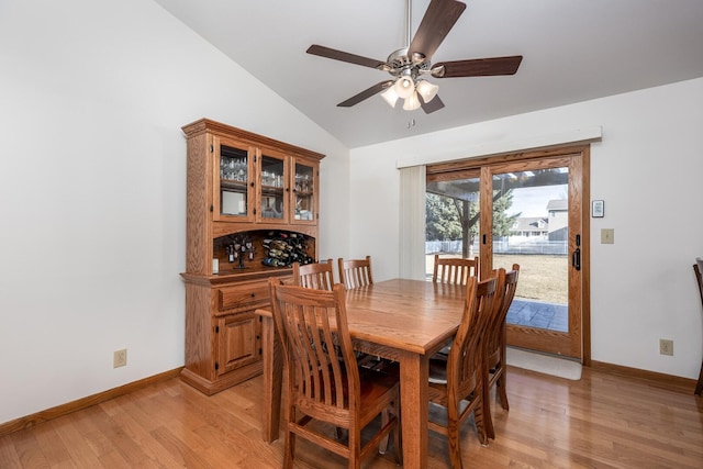 dining space featuring light wood-type flooring, lofted ceiling, ceiling fan, and baseboards