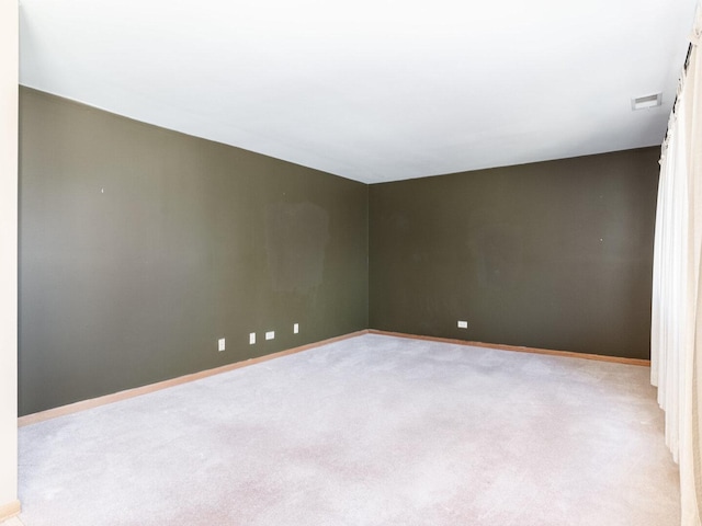 unfurnished room featuring light colored carpet, visible vents, and baseboards