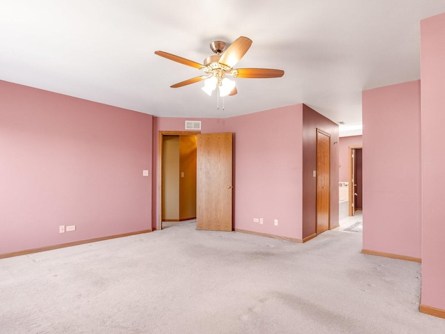 empty room with visible vents, baseboards, carpet, and a ceiling fan