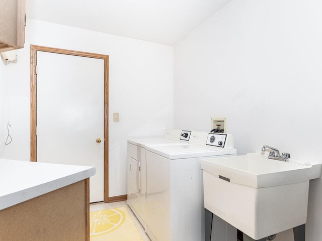 washroom featuring laundry area, washing machine and dryer, and a sink