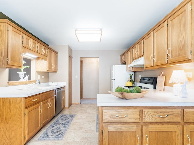 kitchen with under cabinet range hood, a sink, stainless steel dishwasher, freestanding refrigerator, and light countertops