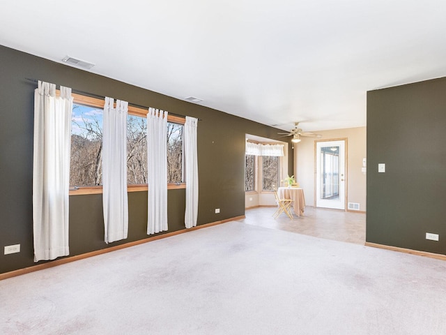 unfurnished living room with visible vents, baseboards, and carpet