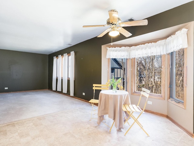 dining area with a ceiling fan and baseboards