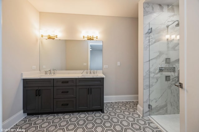 bathroom featuring double vanity, a marble finish shower, baseboards, and a sink