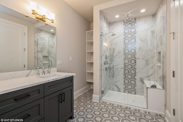 bathroom with recessed lighting, baseboards, vanity, and a marble finish shower