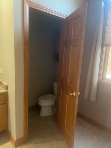 bathroom featuring vanity, toilet, and baseboards