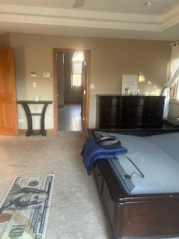 bedroom with a raised ceiling, carpet flooring, and crown molding