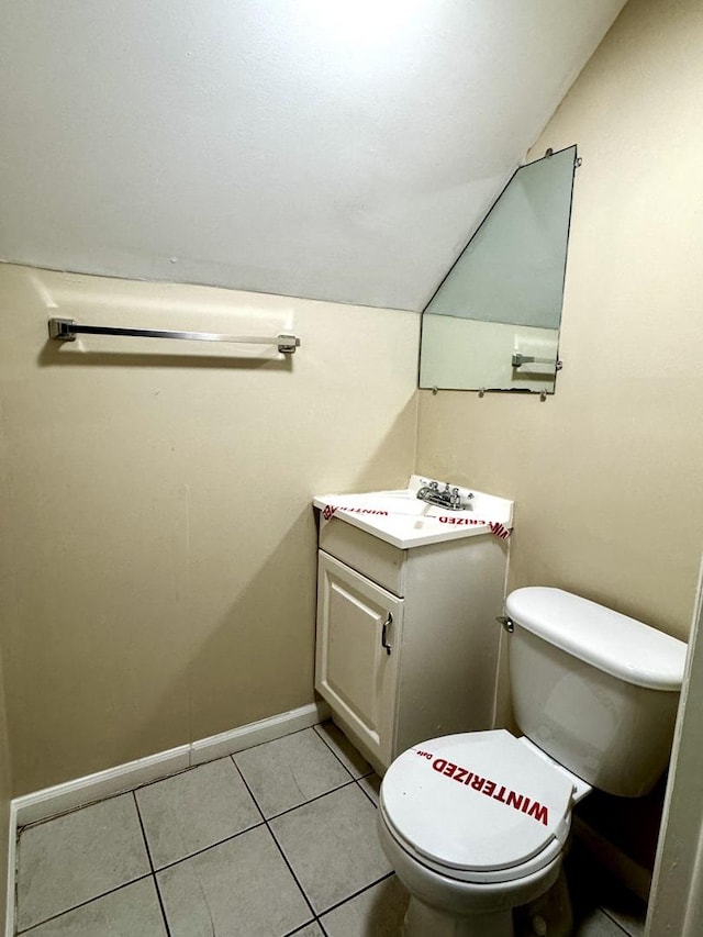 bathroom featuring lofted ceiling, tile patterned flooring, vanity, and toilet