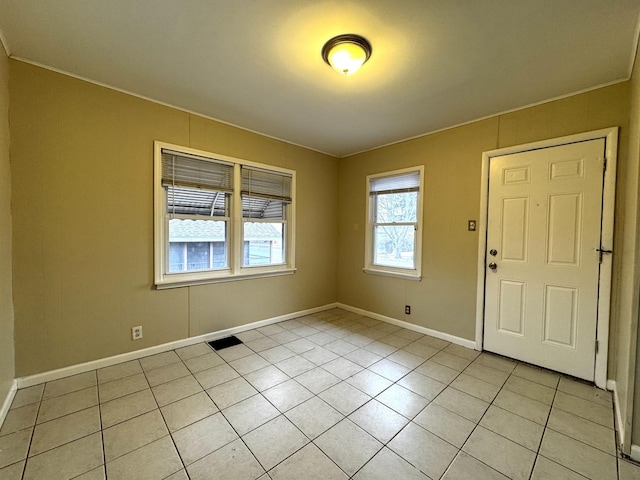 empty room with light tile patterned floors, visible vents, and baseboards