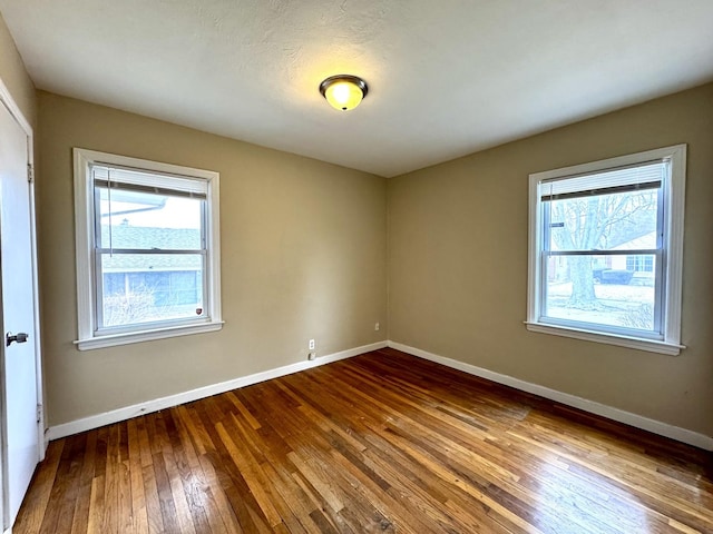 empty room with baseboards and hardwood / wood-style floors