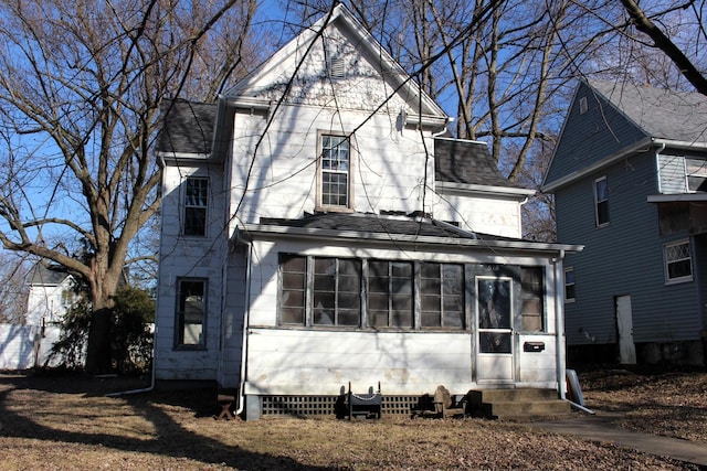 view of front facade featuring roof with shingles and a sunroom