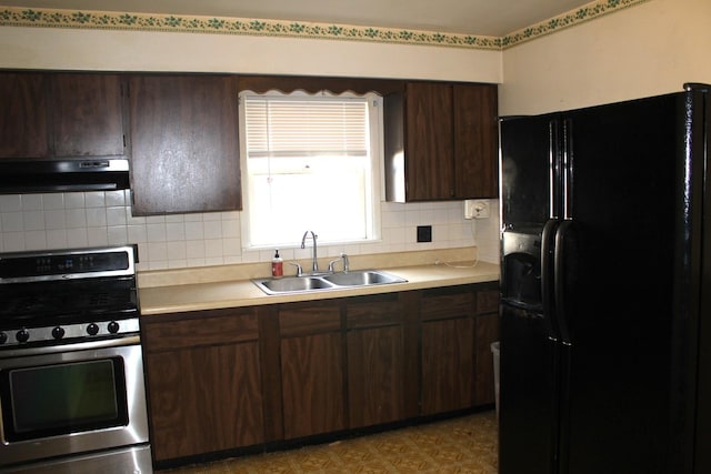 kitchen featuring a sink, under cabinet range hood, gas range, light floors, and black refrigerator with ice dispenser