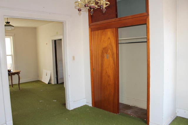 unfurnished bedroom featuring a closet, baseboards, and an inviting chandelier