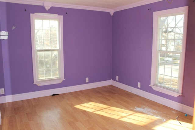 unfurnished room with baseboards, wood finished floors, and ornamental molding