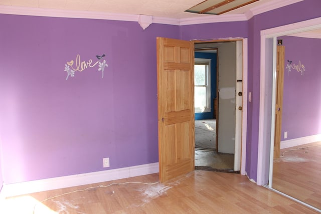 unfurnished room featuring baseboards, wood finished floors, and ornamental molding