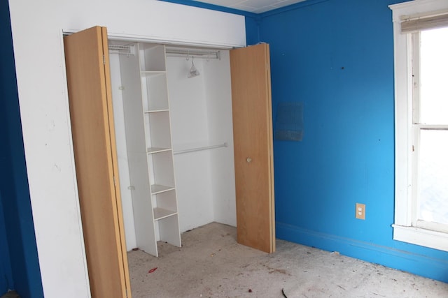 unfurnished bedroom featuring a closet and unfinished concrete floors