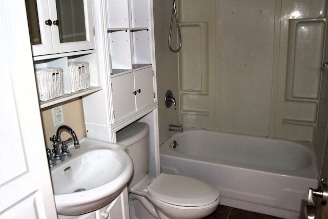 bathroom with tile patterned flooring, toilet,  shower combination, and a sink