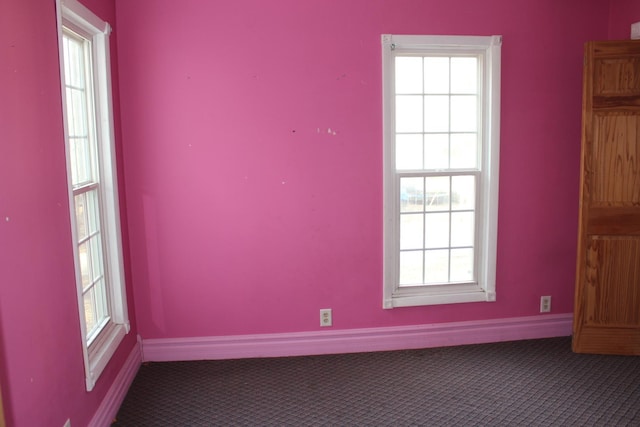 spare room with carpet flooring, baseboards, and plenty of natural light