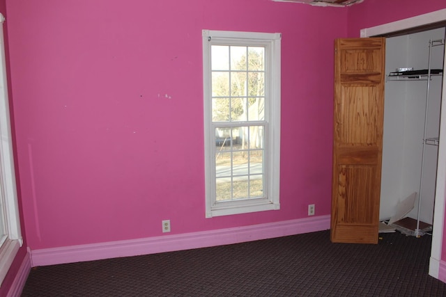 unfurnished dining area featuring carpet flooring and baseboards