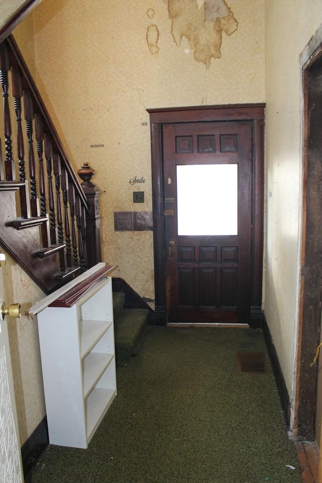 doorway with stairway, baseboards, visible vents, and carpet floors