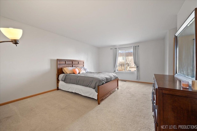 bedroom featuring light carpet and baseboards