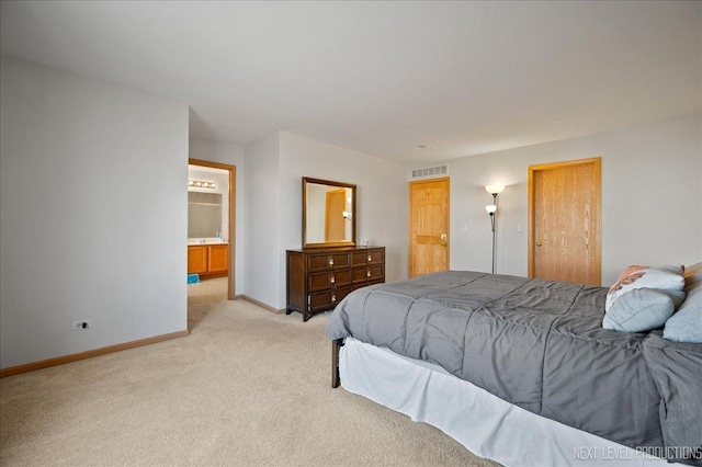 bedroom with light carpet, baseboards, visible vents, and ensuite bathroom