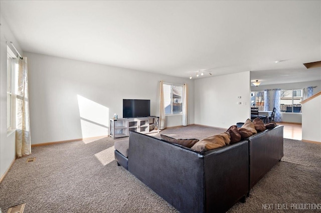 living area featuring a healthy amount of sunlight, carpet, visible vents, and baseboards