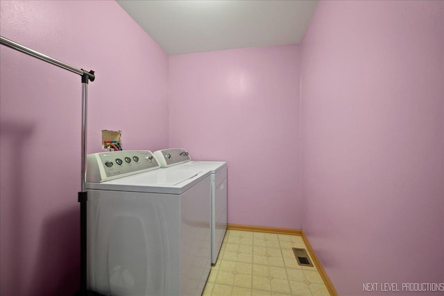 washroom featuring washer and clothes dryer, light floors, visible vents, laundry area, and baseboards