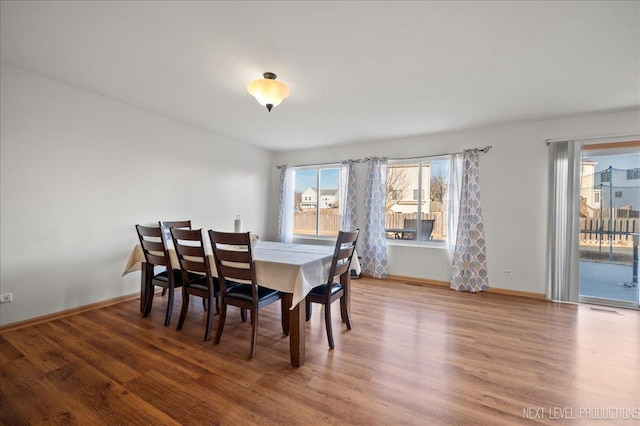 dining room with visible vents, baseboards, and wood finished floors