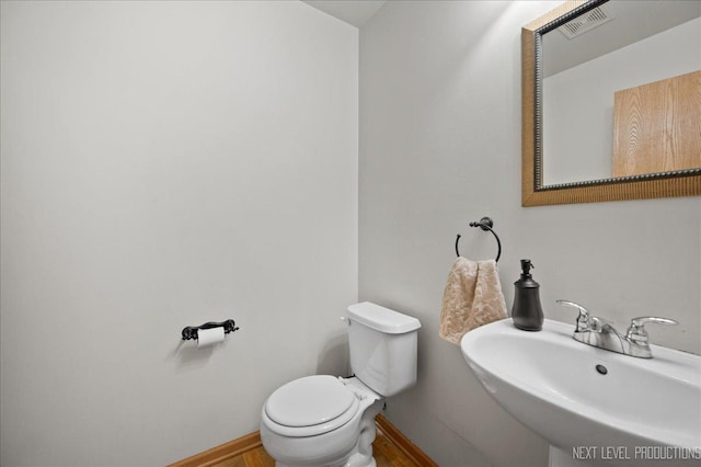 bathroom featuring baseboards, visible vents, a sink, and toilet